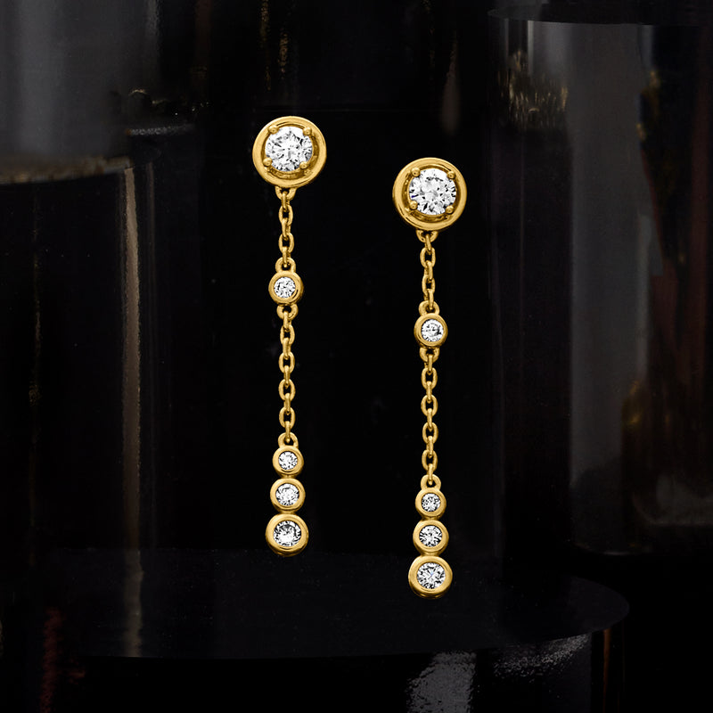 Gold five-stone linear diamond drop earrings with round bezel-set stones on chain