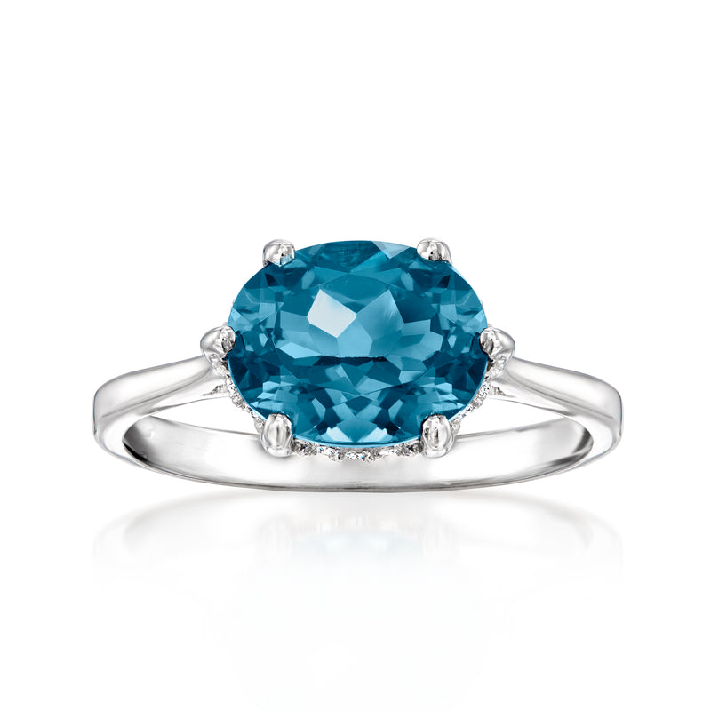 Sterling silver ring with oval blue topaz center and small diamond accents, four-prong setting