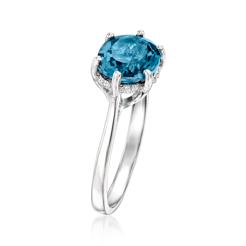 Sterling silver topaz ring, side view with prongs and diamond halo around oval blue gemstone