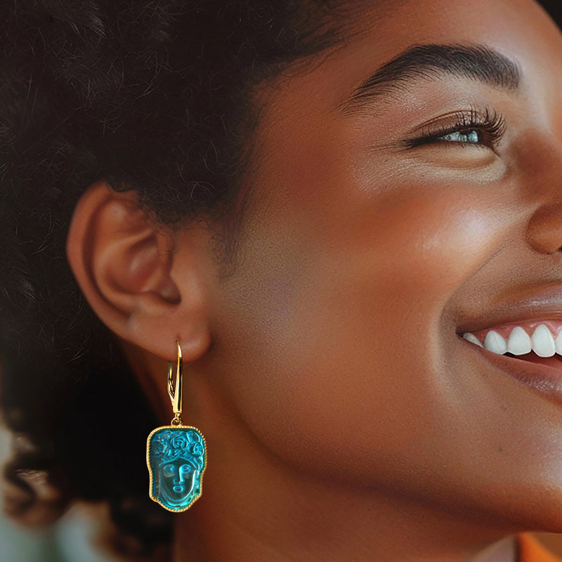 Gold leverback drop earring with blue glass face pendant framed in gold