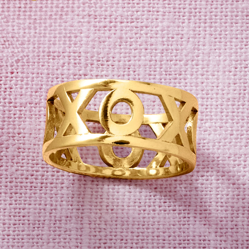 Gold XO ring close-up with X and O cutouts in oval band