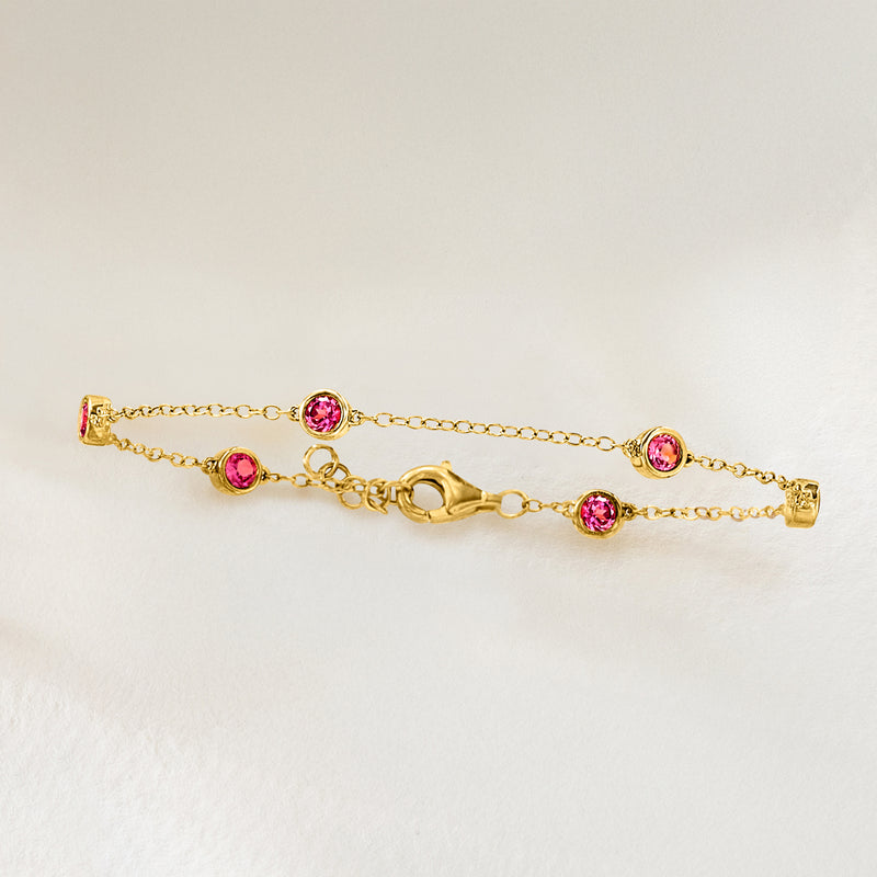 Gold station bracelet with four round pink gemstones and extender chain