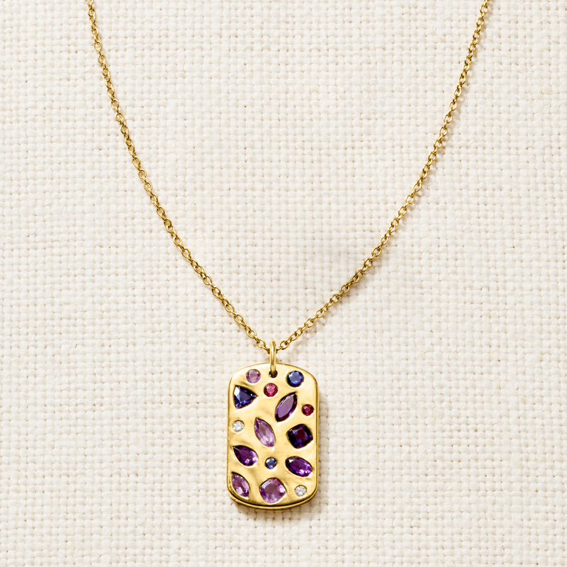Gold tag pendant with purple gemstones and clear diamond details