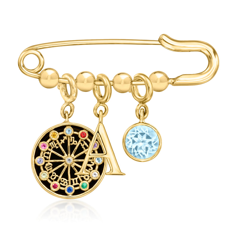 Gold-tone safety pin with dangling round charm and blue gemstone charm