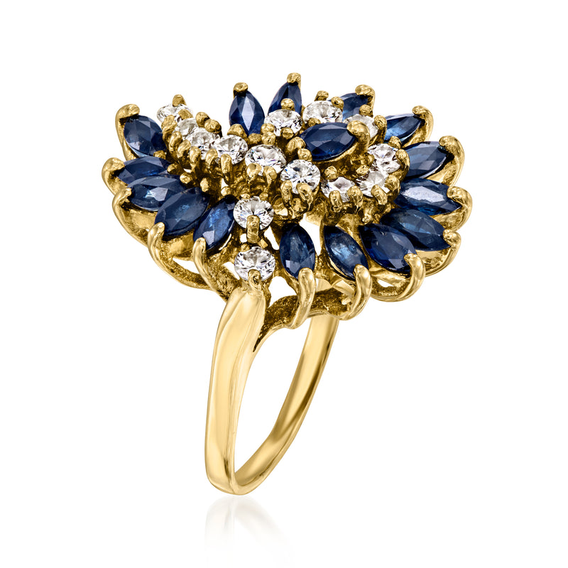 Yellow gold openwork swirl ring with blue oval sapphires and round diamond accents