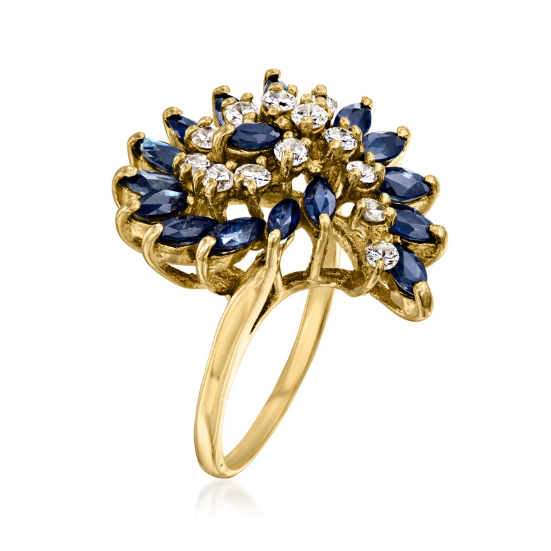 Gold statement ring with blue sapphires and round diamonds in raised swirl setting