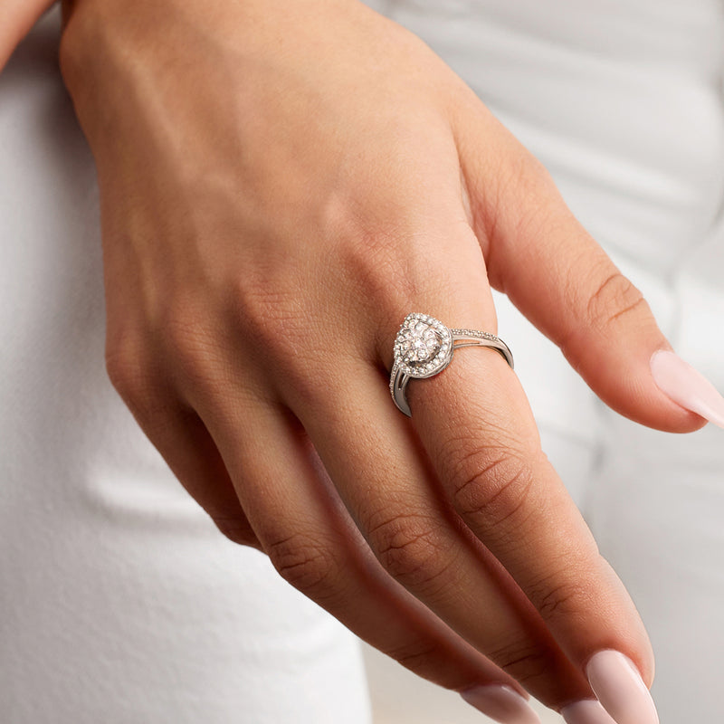 Pear-shaped diamond halo ring on hand, 14kt white gold band