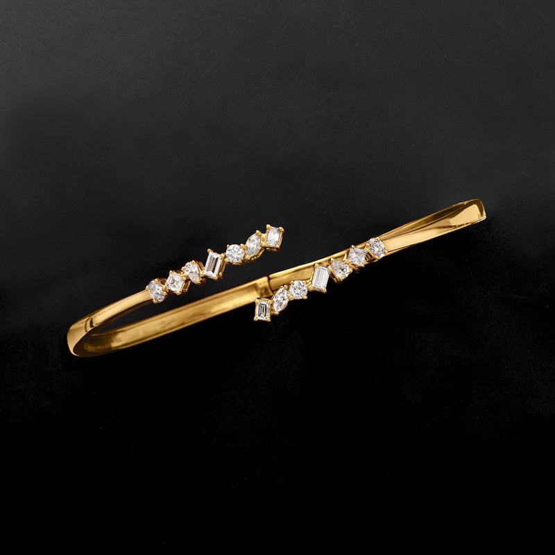 Gold cuff bracelet with lab-grown diamond bar design along hinged open bangle