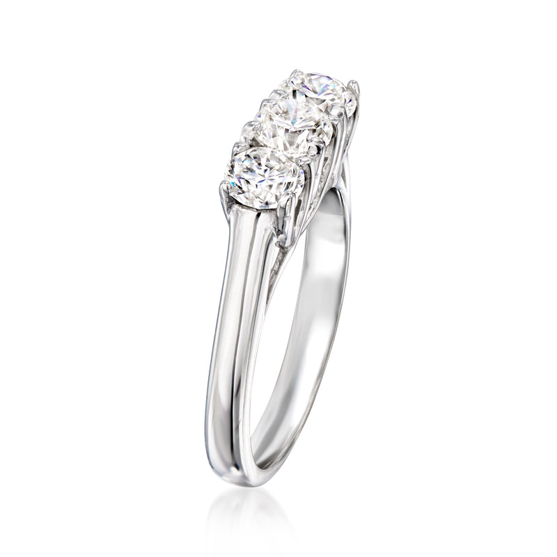 Three-stone diamond ring in white gold, angled view of round-cut settings