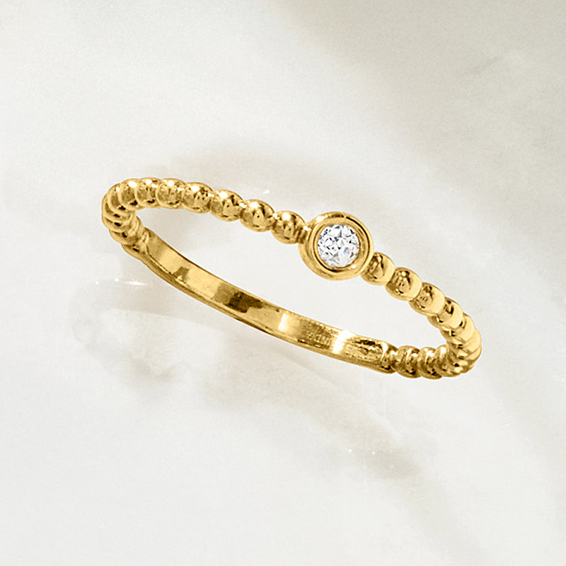Gold beaded band ring with round diamond bezel, side view