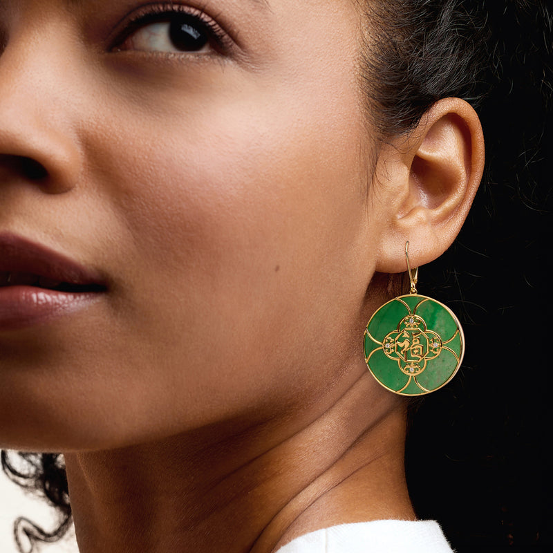 Green jade-look round drop earrings with gold zodiac motif, shown on ear
