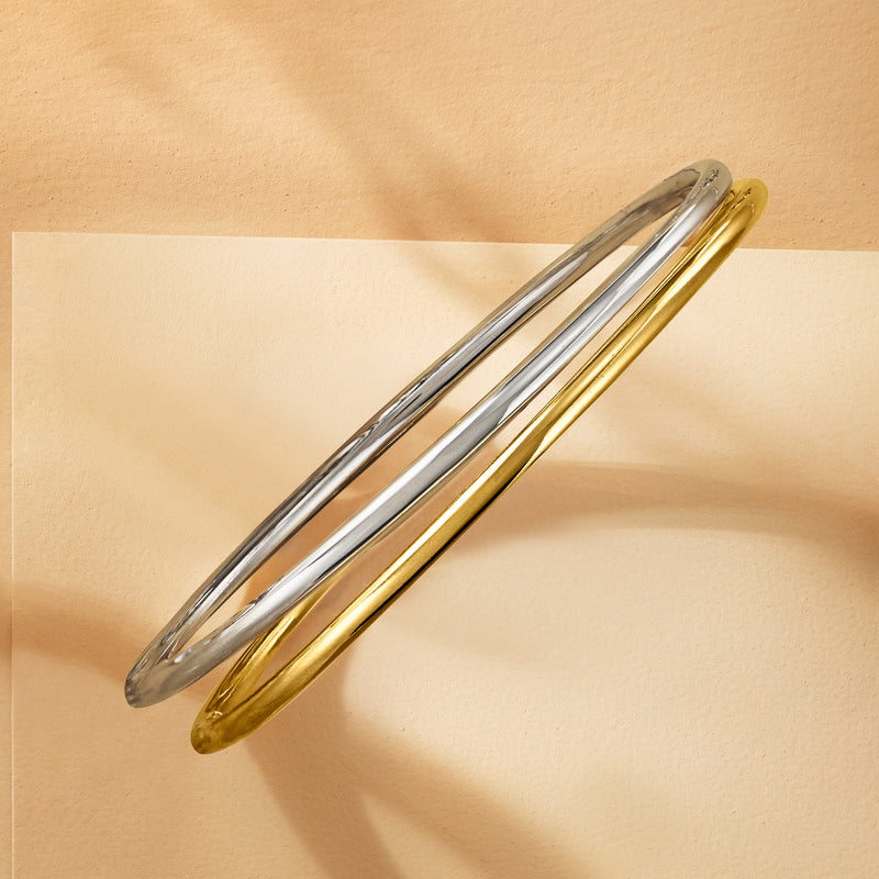 Two-tone polished bangle bracelets, gold and silver overlapped
