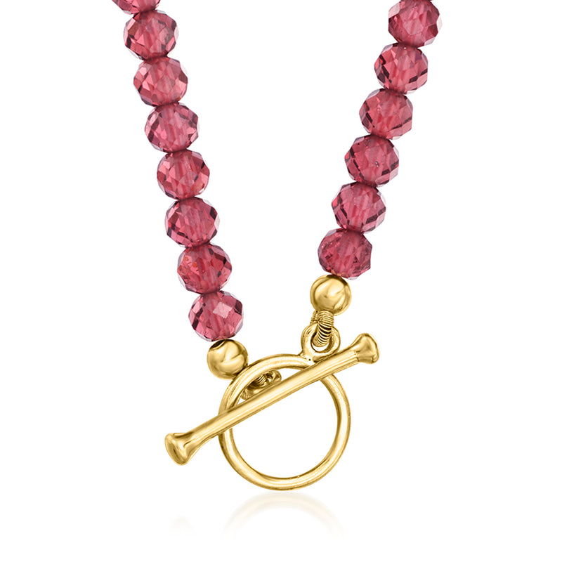 Garnet bead toggle necklace detail: gold toggle clasp and sun charm, pink faceted beads