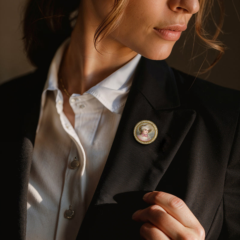 Oval portrait pin on black blazer lapel, 15kt yellow gold with diamond trim