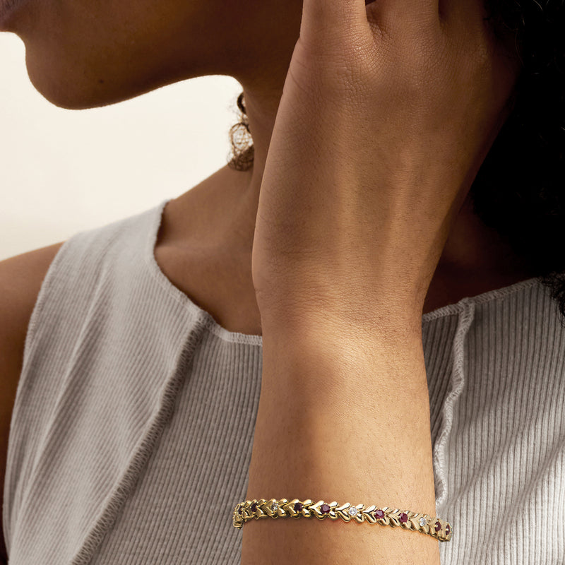 14kt yellow gold ruby and diamond bracelet worn on wrist with oval stone links