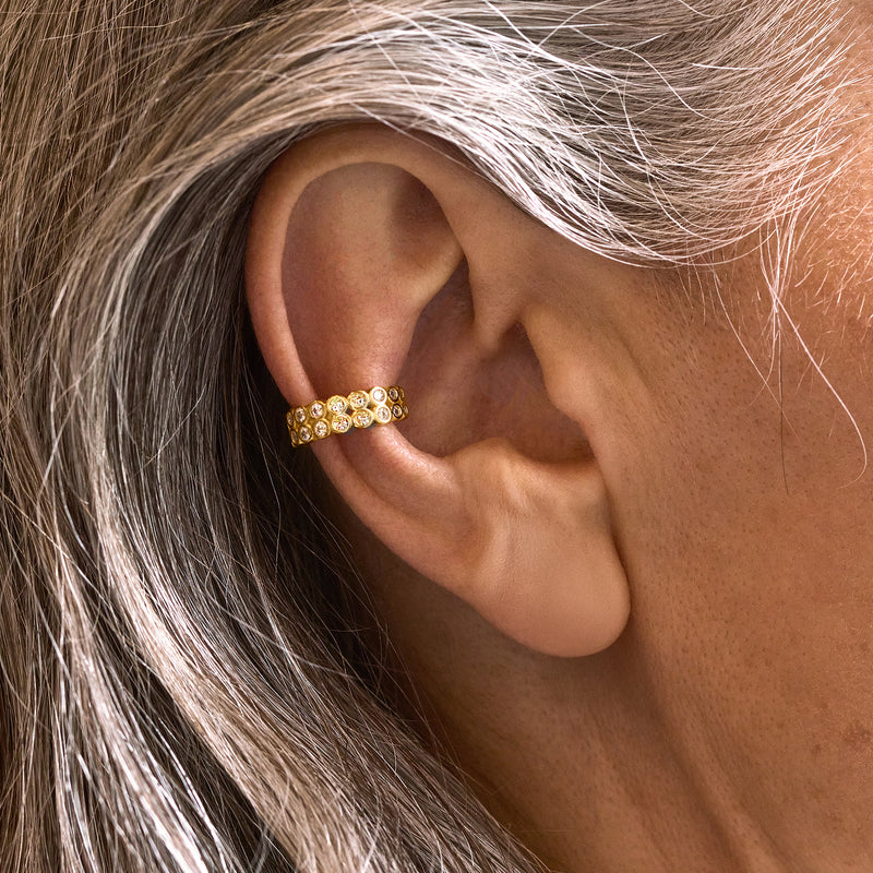 Single CZ ear cuff on ear, 18kt gold over sterling with a row of round clear stones