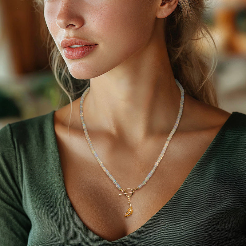 Tiger eye leaf charm in gold over sterling, worn on a fine beaded necklace