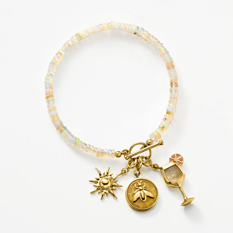 Opal bead charm toggle bracelet with sun, coin, and wine glass charms