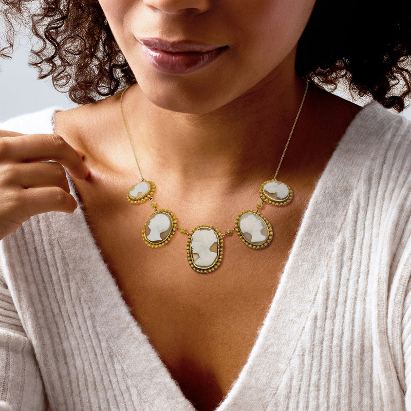 Brown shell cameo necklace on model: five oval cameos, yellow-gold chain