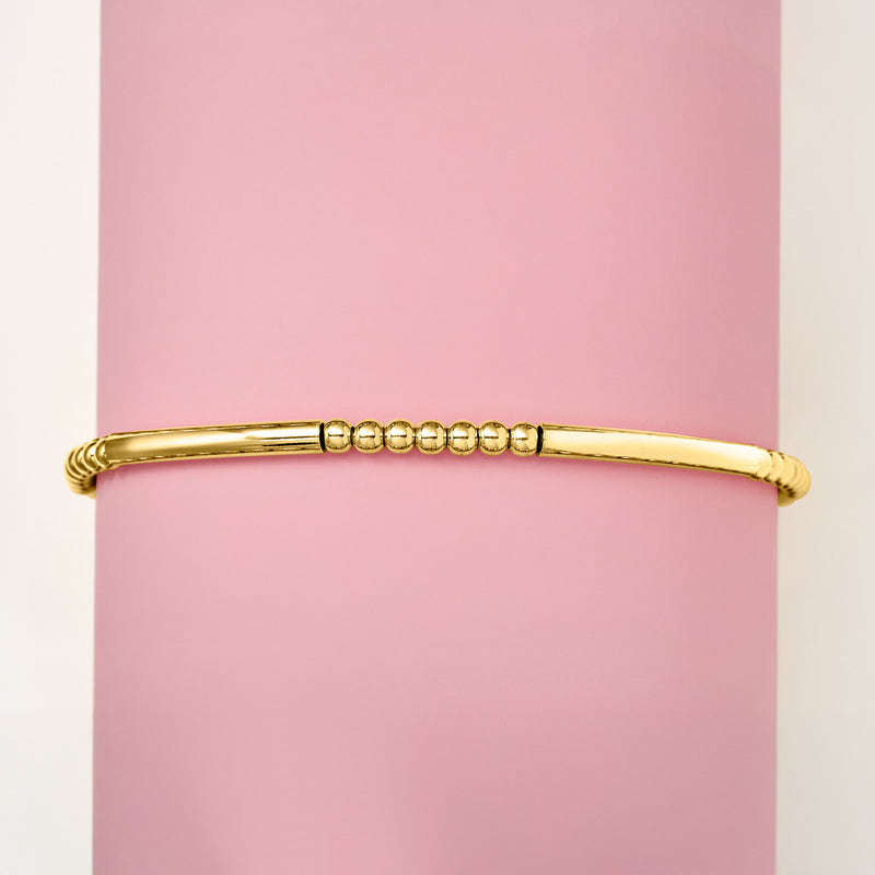Gold stretch bracelet with tube bar and round bead segments