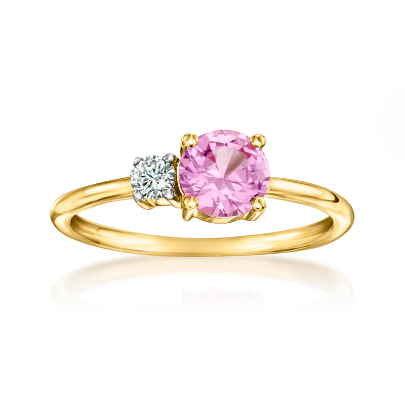 Gold ring with oval pink sapphire center and two clear diamond accents