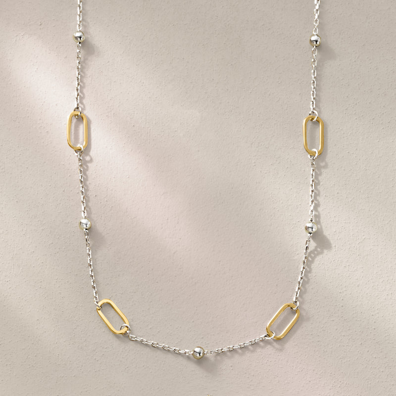 Paper clip link station necklace featuring silver chain and gold oval links, front view