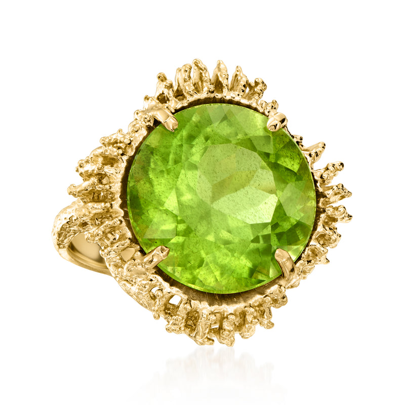Gold peridot ring featuring a round green gemstone and textured halo prongs