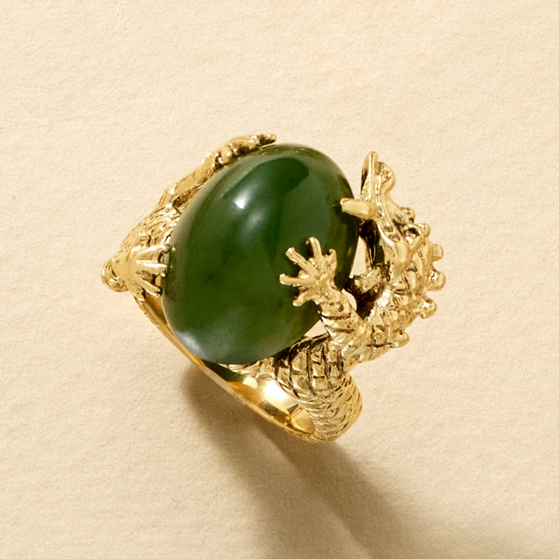 Yellow gold dragon ring featuring a glossy oval green stone, angled view