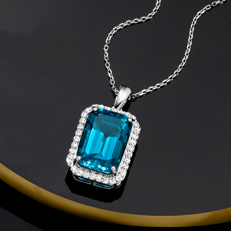 Platinum pendant with blue topaz and diamond halo border on chain