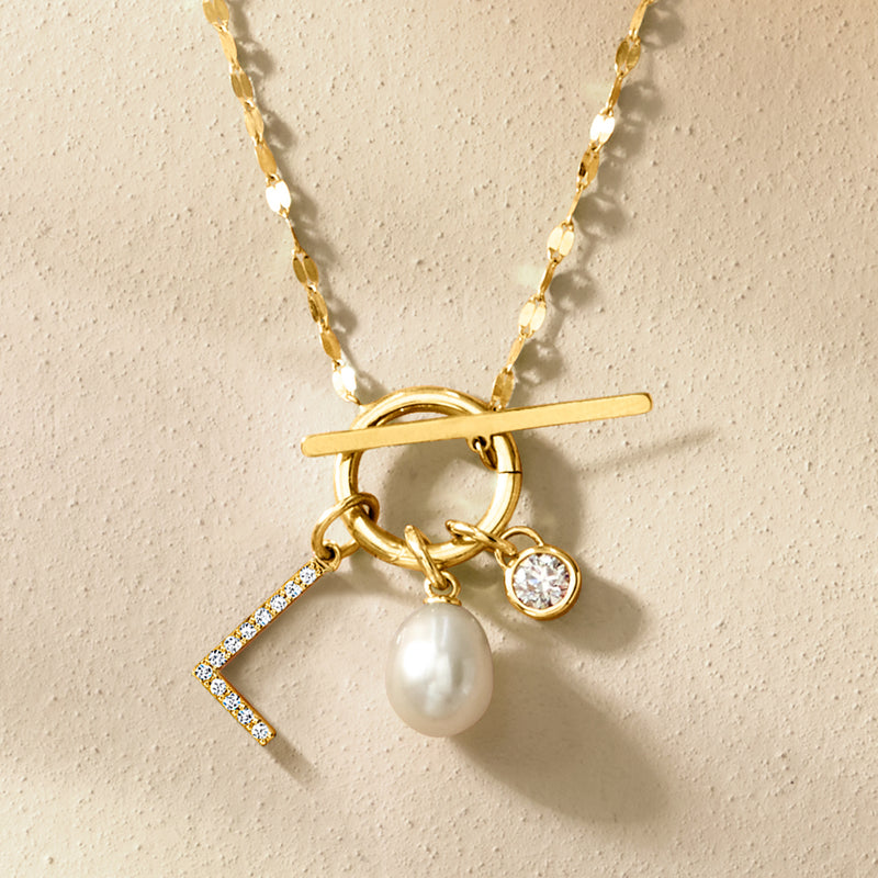 Gold charm with oval pearl, bar dangle, small crystal stones, and ring