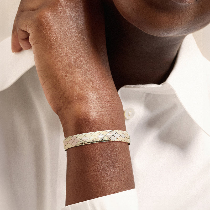 Tri-colored gold fancy-link bracelet on wrist, patterned links and square clasp