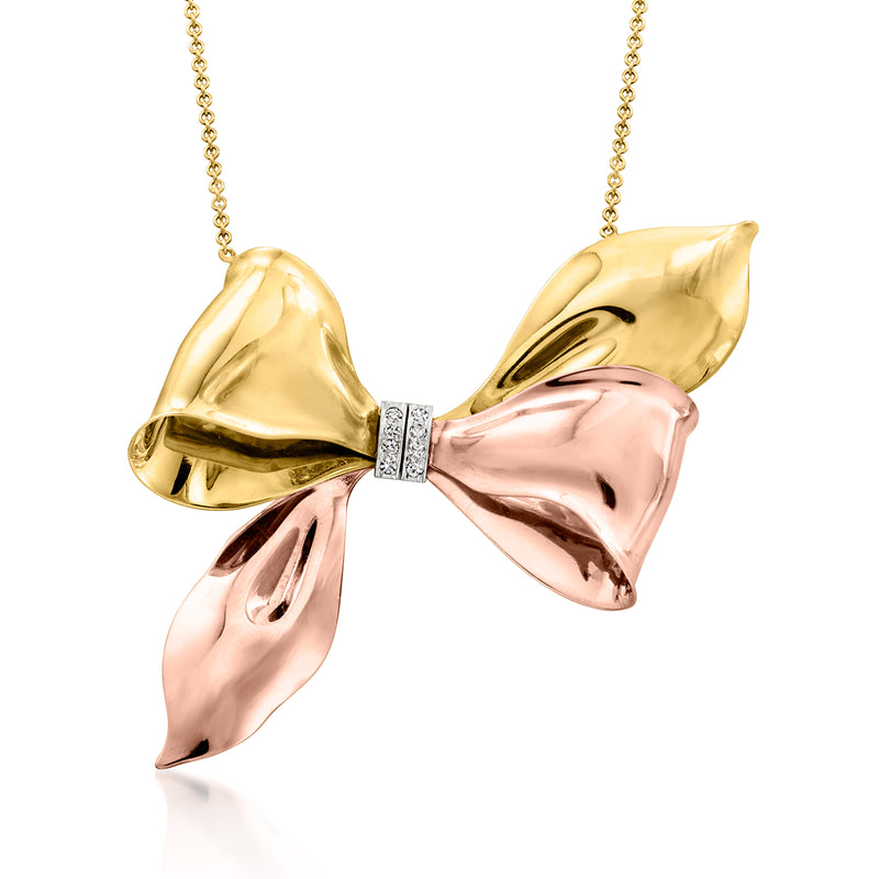 Two-tone gold bow necklace with diamond center, hanging on chain
