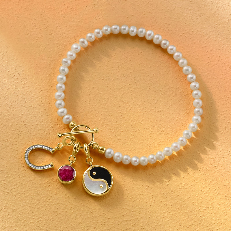 Yin-yang mother-of-pearl and onyx charm on white pearl bead necklace in gold