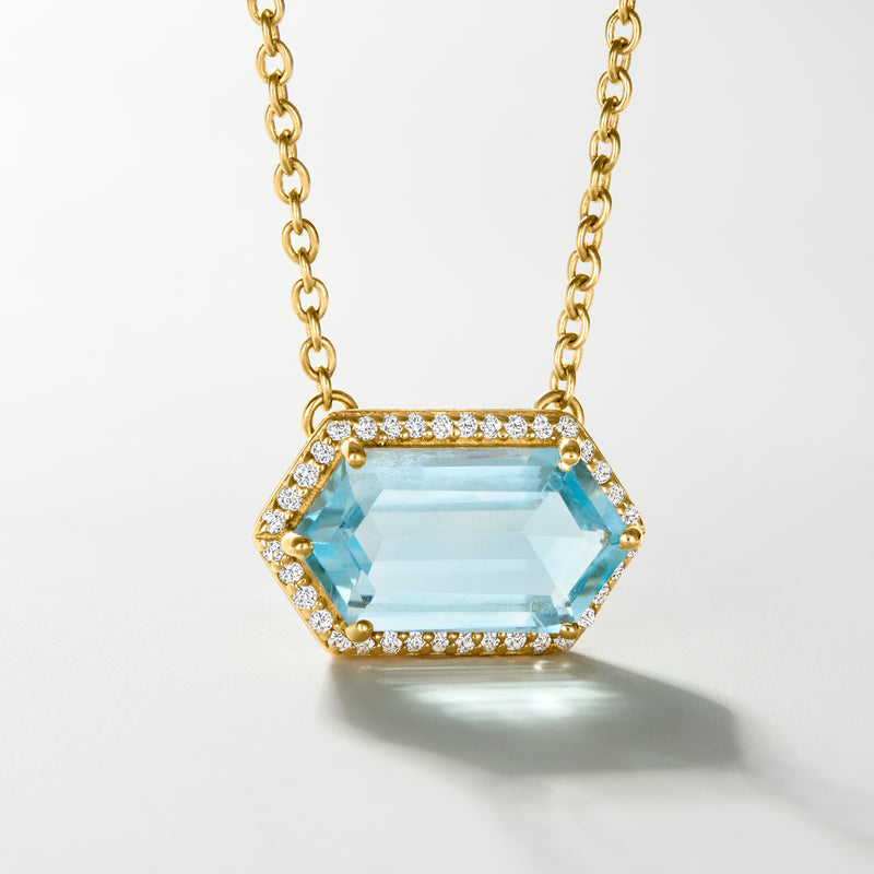 Gold over sterling necklace with hexagonal light blue gemstone and white topaz halo