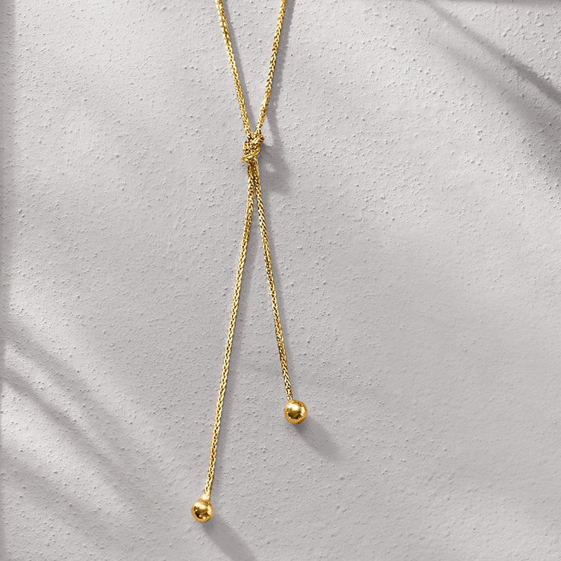 14kt yellow gold lariat knot necklace, knot centerpiece with two hanging bead drops