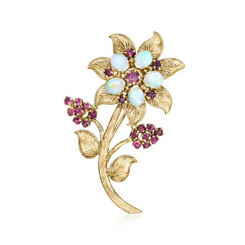 Vintage yellow gold flower pin with blue opal-like stones and purple ruby accents