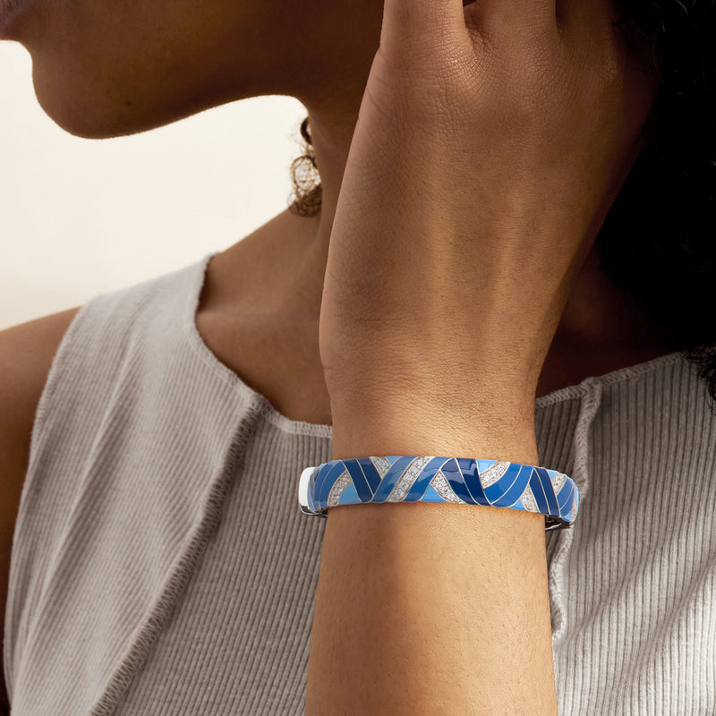 Blue enamel bangle bracelet on wrist with geometric sterling silver and CZ detailing