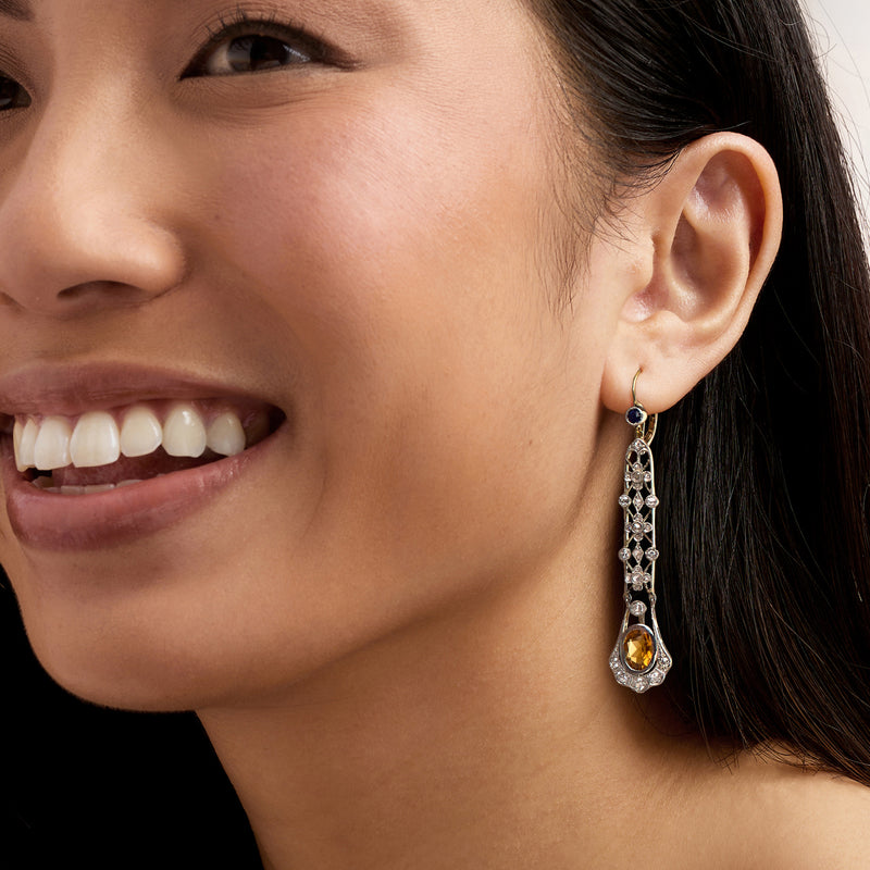 Leverback drop earrings on model: citrine teardrop with sapphire blue center and diamonds