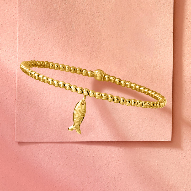 Gold beaded stretch bracelet with small fish charm pendant