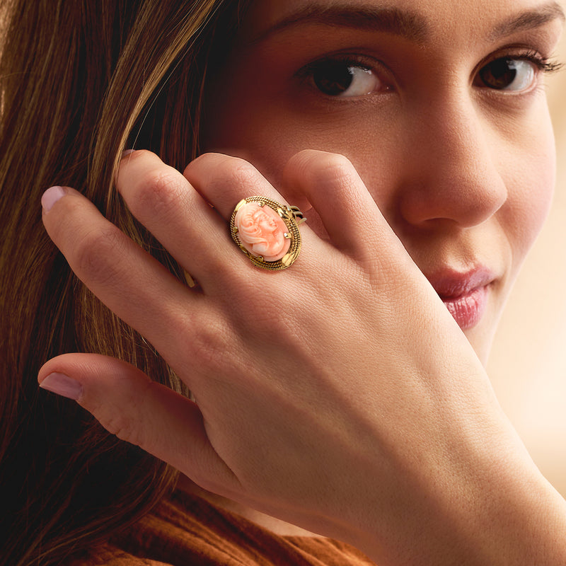 14k yellow gold cameo ring on hand, pink coral oval profile centerpiece
