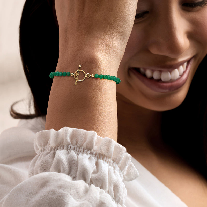 Emerald bead toggle bracelet on wrist with gold-tone clasp