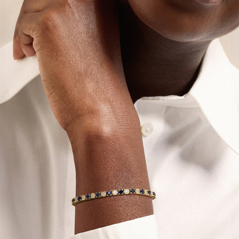 18kt gold-over-sterling tennis bracelet with blue sapphire and clear diamond stones on wrist