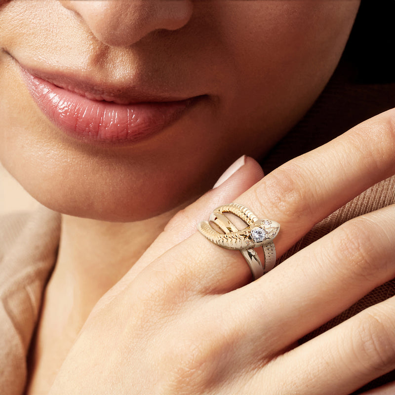 14kt yellow gold snake ring with round diamond on finger, close-up