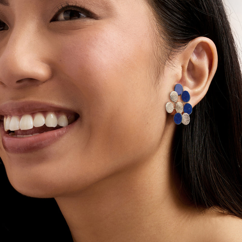 Geometric lapis blue and gold-tone clip/post earrings on ear, round disc cluster