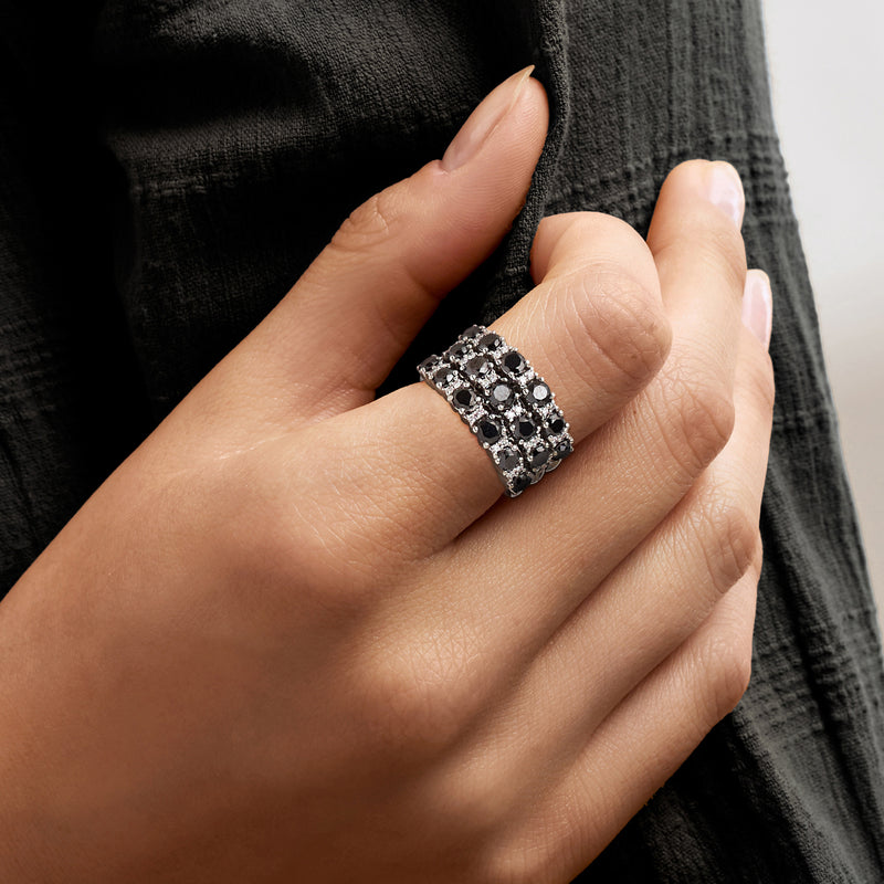 Black and white diamond band ring on hand, square-set stones on white gold