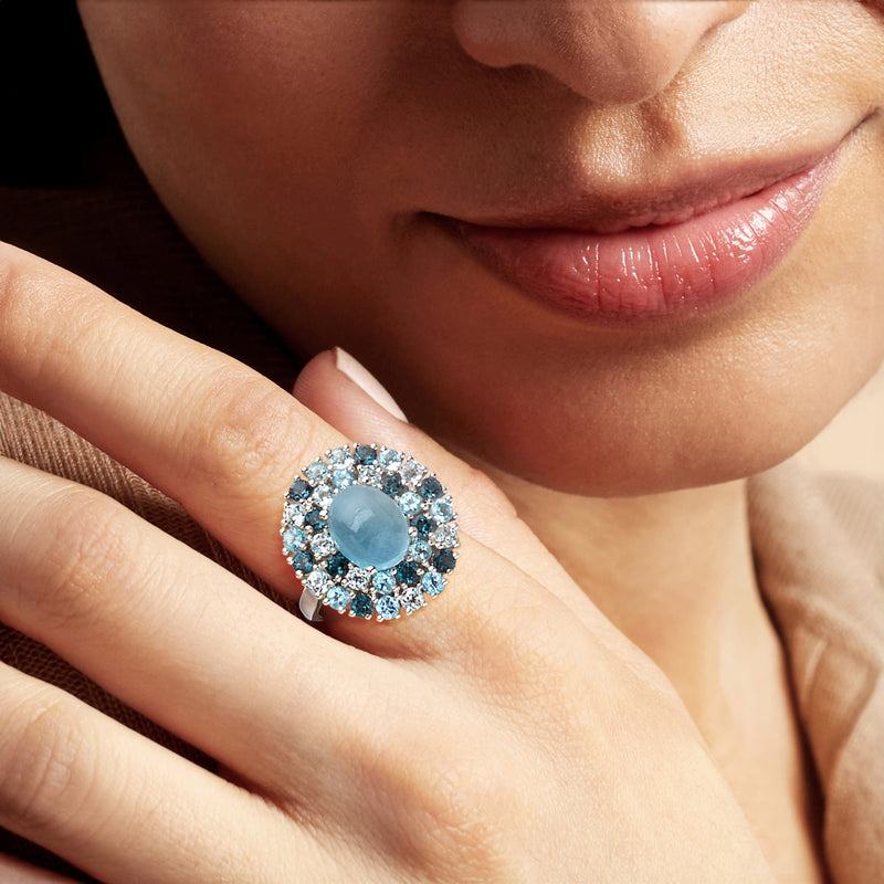 Oval milky aquamarine halo ring on finger, blue stones in sterling silver