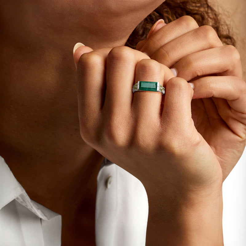 Sterling silver ring with green rectangular center stone and peridot accents on hand