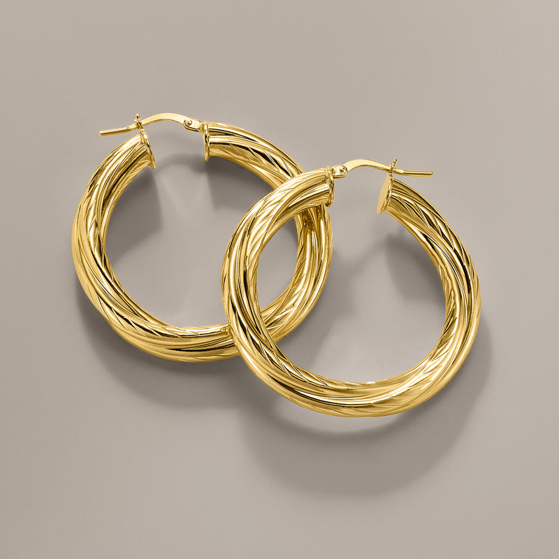 Pair of twisted gold-plated hoop earrings with cable-like spiral texture, front view.