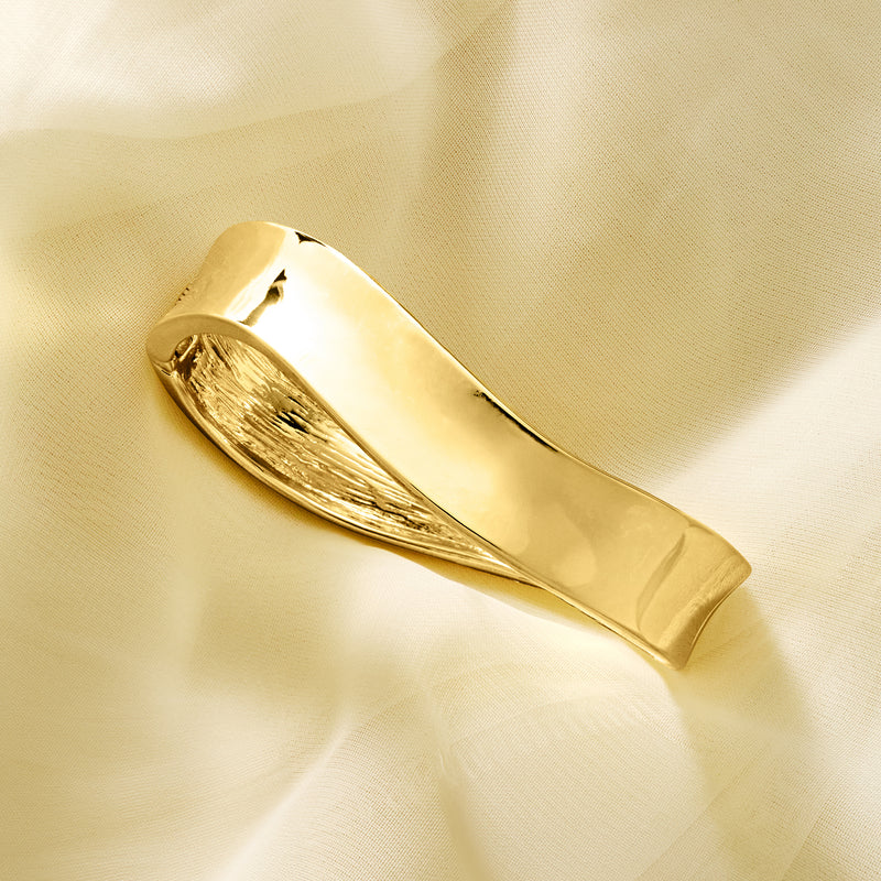 Yellow gold-plated wavy bangle bracelet close-up of textured inner channel