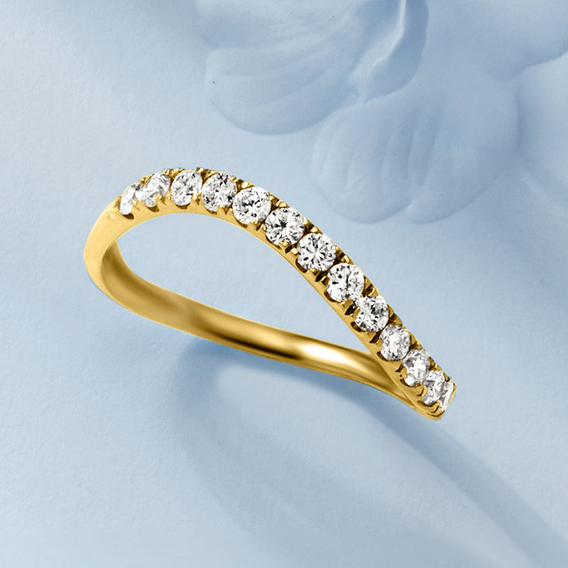 Angle view of wavy gold ring with round lab-grown diamonds along the band